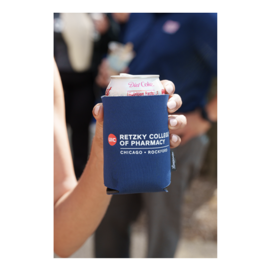 Hand holding Retzy College of Pharmacy branded foam drinkholder
