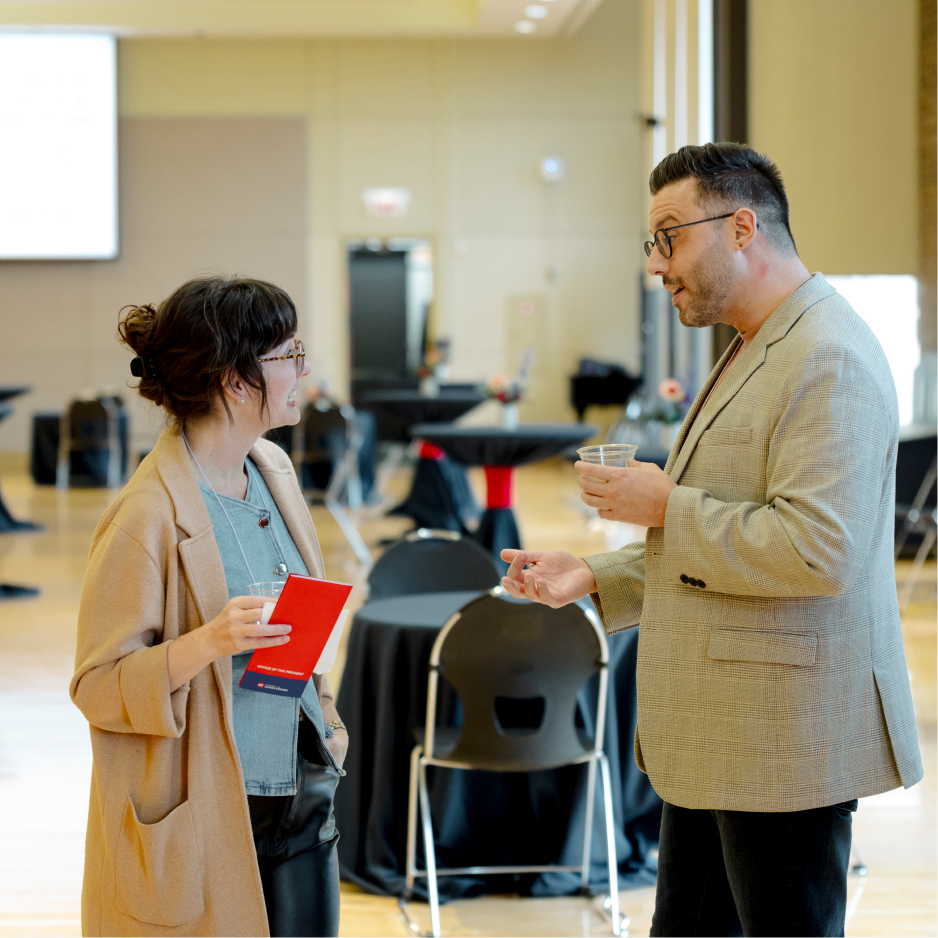 Two campus communicators talking together at an event.